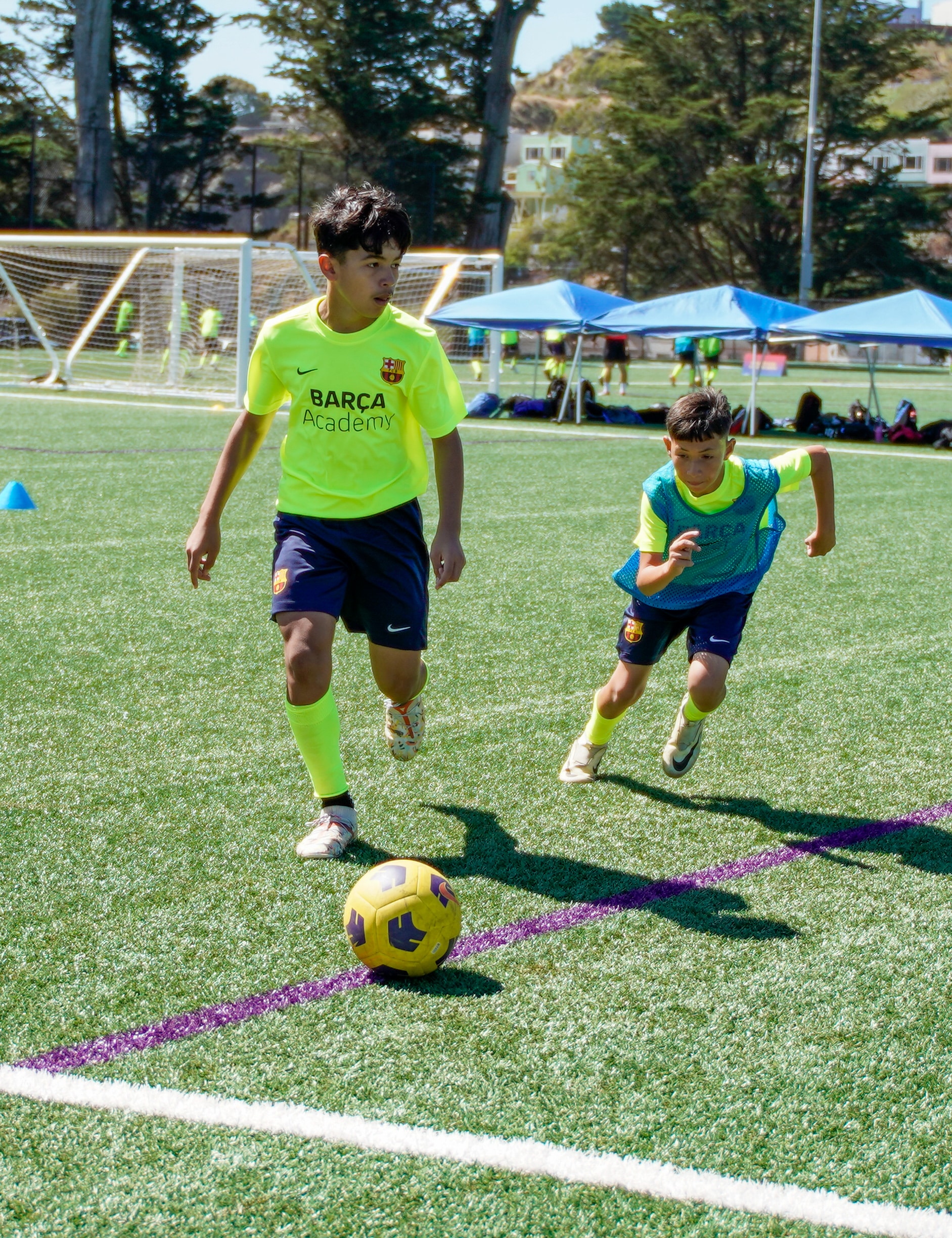 Two kids training to master the chip shot in soccer